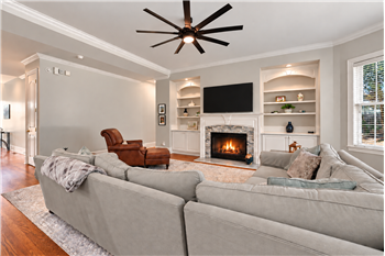 Gas log fireplace with decorative mantel framed by custom built-ins. Great combination of architectural detail, useful storage.