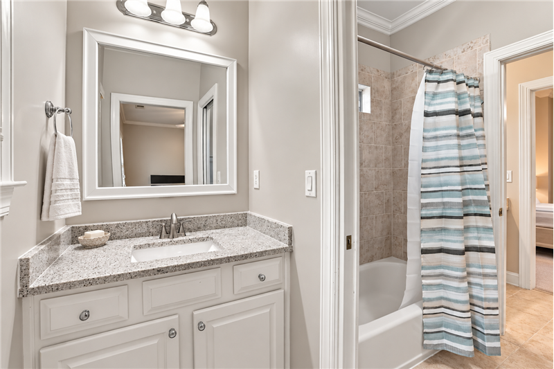 Jack & Jill bathroom with private granite topped vanity. Shared tub/shower with tile surround.