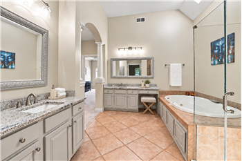 Two granite-topped vanities provide abundant counter and storage space.