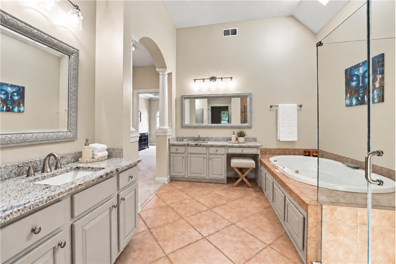 Two granite-topped vanities provide abundant counter and storage space.