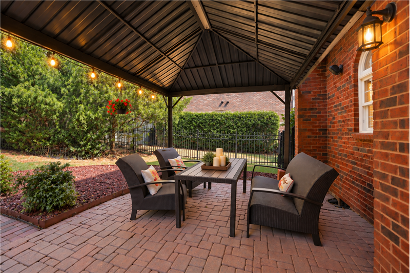 Covered brick paver patio is a natural extension of the home's living and entertaining areas.