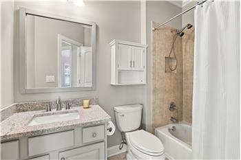 Hall bath shared by two of the bedrooms on the home's second floor. Granite topped vanity, tub/shower with tile surround.
