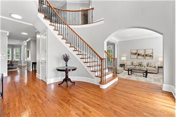 Formal living room to right of foyer is framed by a wide arched entry.