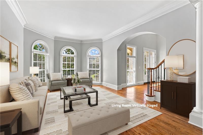 Dramatic arched windows, custom architectural details give the spacious formal living room a luxurious feel.