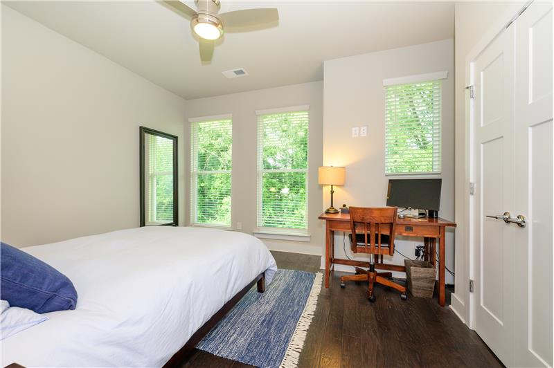 Primary bedroom bright and sunny with view of trees; ceiling fan; 9 foot ceilings.