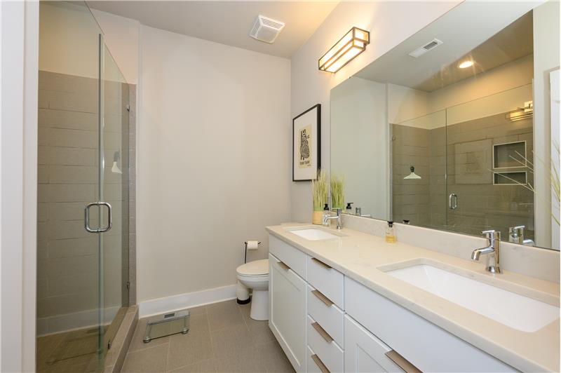 En-suite owner's bathrooms with extended double-sink vanity with European flat-panel cabinets.