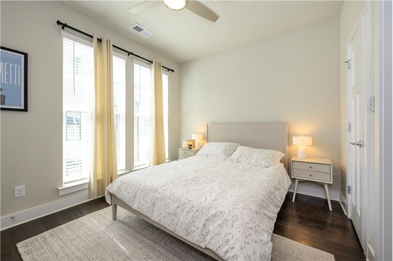 Light-filled, second bedroom features hardwood floors, en-suite bathroom, ceiling fan, 9 foot ceilings.