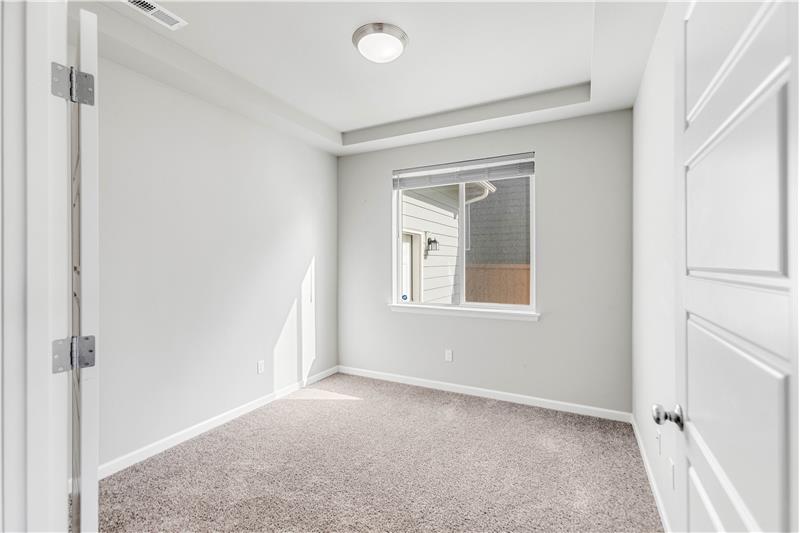 The main-level office features a recessed ceiling detail, recessed lighting, a window, and French doors.