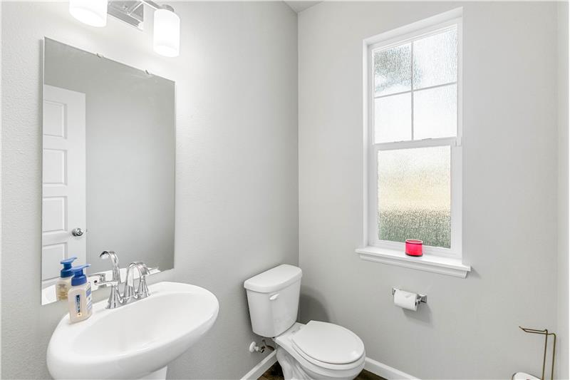 A main-level half bath adds everyday convenience, with a vanity and window.
