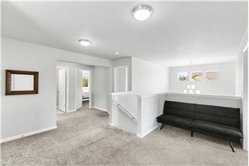 The spacious second-floor landing offers a cozy spot to curl up with a book or enjoy a quiet moment between rooms.