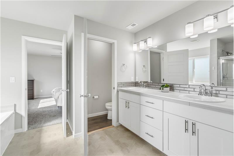The primary suite connects to a 5-piece en suite featuring dual sinks, a separate water closet, a bathtub, and a shower