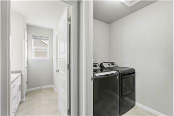 A second-floor laundry room sits close to all the bedrooms for everyday convenience, and the washer and dryer stay with the home