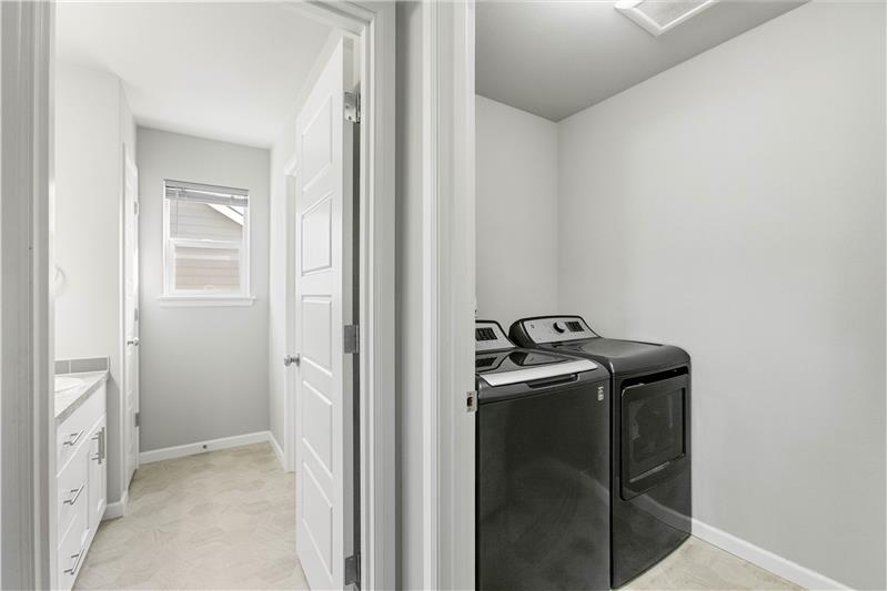 A second-floor laundry room sits close to all the bedrooms for everyday convenience, and the washer and dryer stay with the home