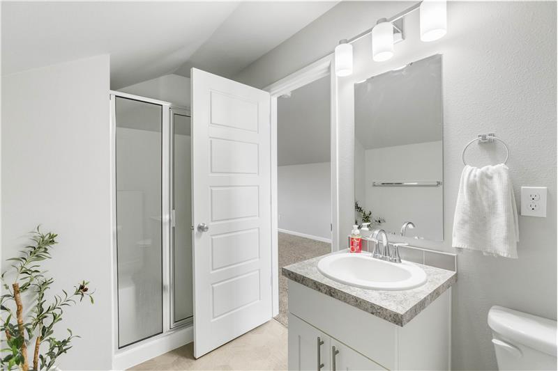 The third-floor three-quarter bath features a shower and vanity, conveniently located just off the bonus room.