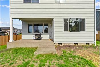 The covered concrete patio offers a sheltered spot for outdoor dining or relaxing.