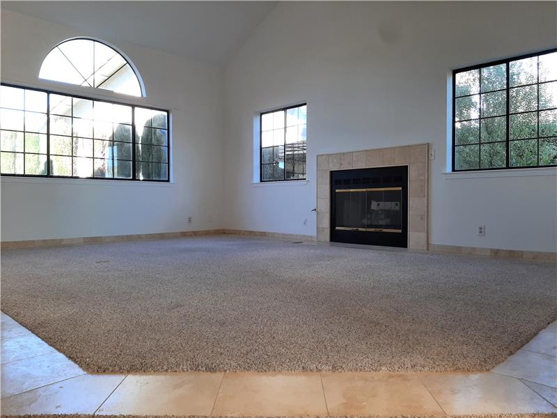 Travertine perimeter with inlaid carpet creates a center space for Living. Multiple windows keep the Living Room alive!