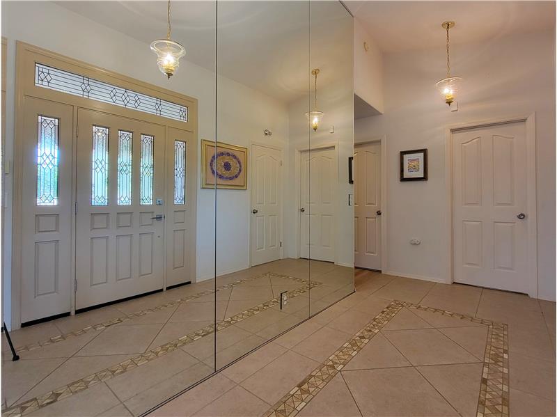 A typical foyer introduces you to the rest of the home; this foyer, with its floor-to-ceiling mirror, makes an Announcement!