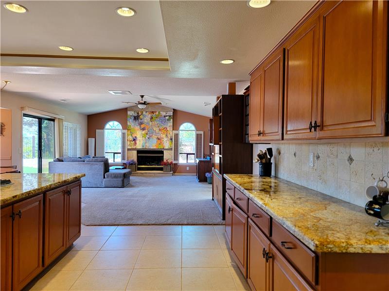 The natural tones continue with custom backsplash, granite counters and wood cabinetry!