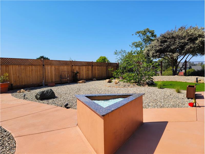 Granite trimmed gas fireplace. To the right, 1 of 8 Corten Steel Planters brought in as part of the back yard redesign!