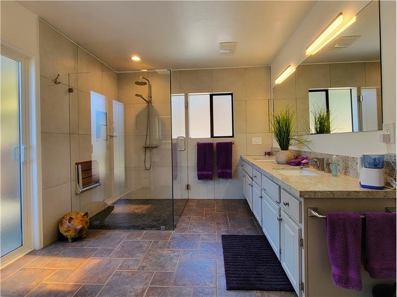 Roll-in shower, wall tiles w/integrated medicine cabinet, Quartz counter tops w/under mounted dual sinks.