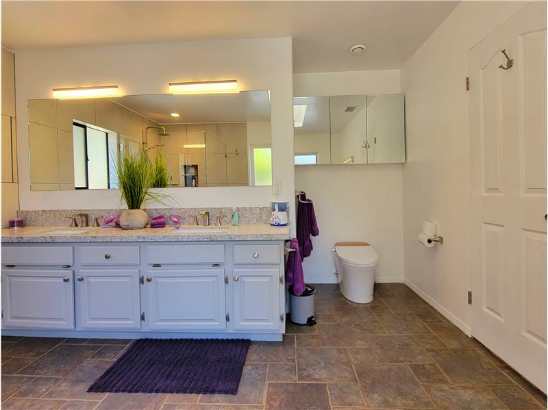 Heated bidet, brushed nickel fixtures and lighting and stone tile flooring.