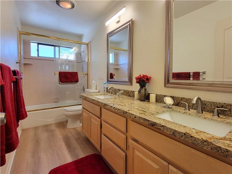 Main bath with granite counters, undermounted sinks, updated lighting, mirrors and flooring!!