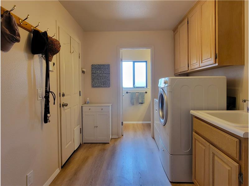 Utility Room positioned between 3 Car Garage and Kitchen. Smart design is having that deep tub sink near the garage!