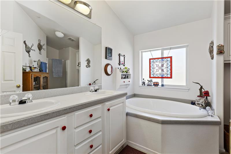 master bath with dual vanities, separate tub and shower