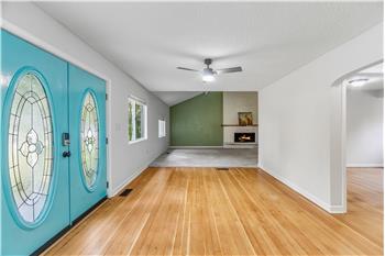 Facing towards the living room, there is a floor to ceiling brick fireplace in the living room.