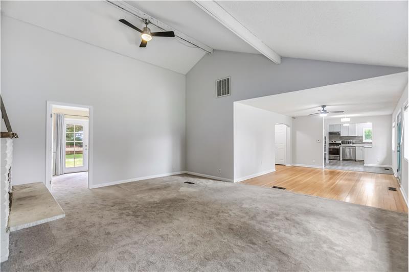 The dining room flows into a living room with tall vaulted ceilings, creating a spacious feel.