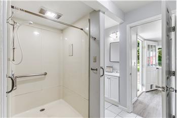 The bathroom features a walk-in shower with grab bars and a no-step entry for added ease of access.