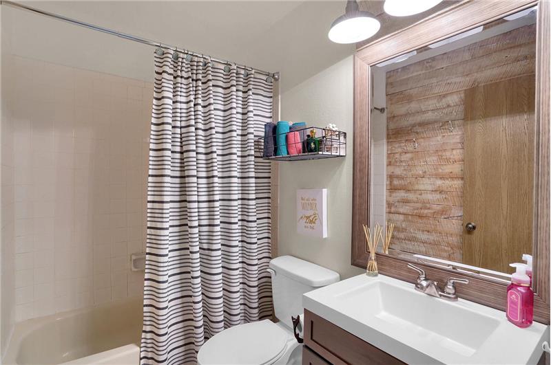 Full upper-level Shower Bathroom with single sink vanity and tub/shower.