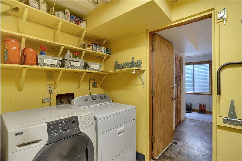 The Laundry Area is in the garage outside of Basement Bedroom #3 with built-in shelves and a washer/dryer that stays.
