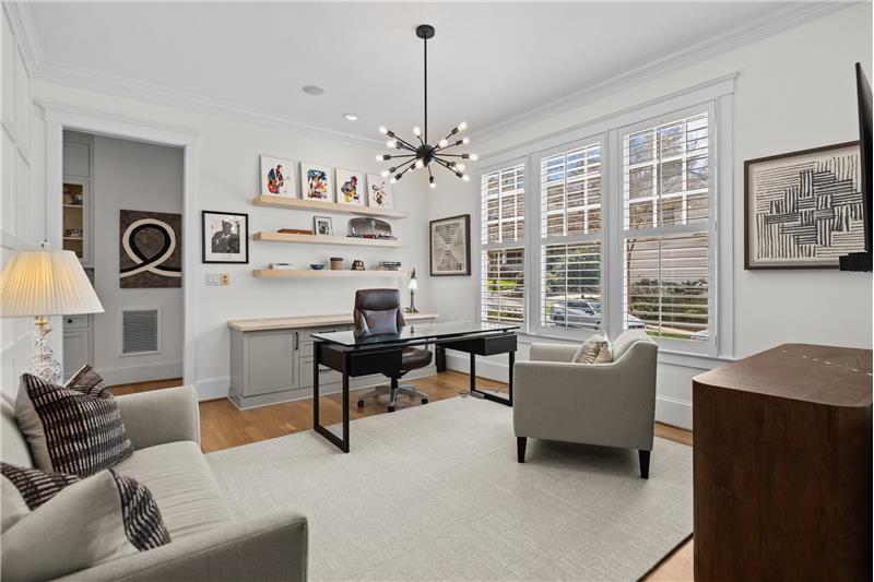 Home office features custom millwork, built-in cabinet and shelves, designer chandelier, plantation shutters.