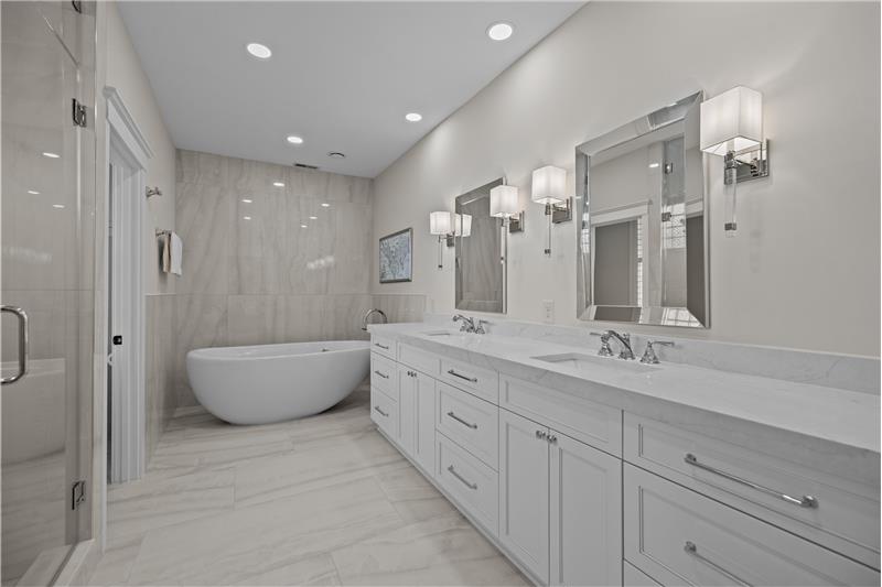 Spa-like primary bathroom with free-standing soaking tub, quartz surround and counters, expansive double sink vanity.
