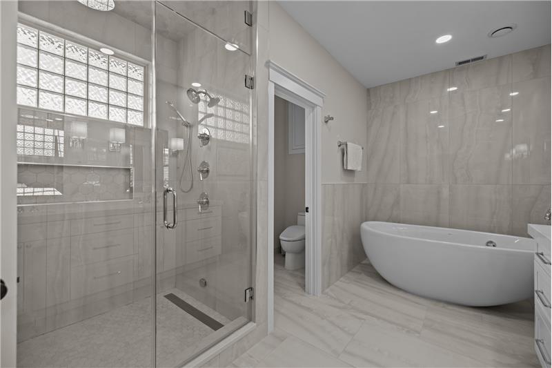 Primary bathroom features double sized steam shower with quartz surround, heated floors, private WC.
