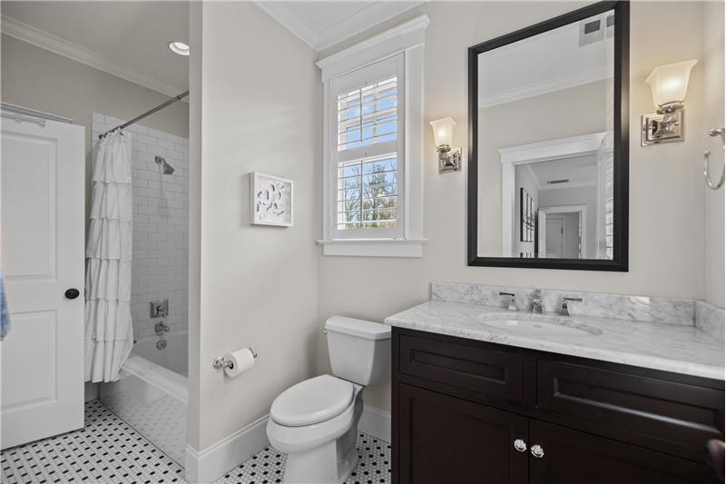 Updated Jack & Jill bathroom shared by two bedrooms. Tile floors, tile surround, crown molding, plantation shutters.