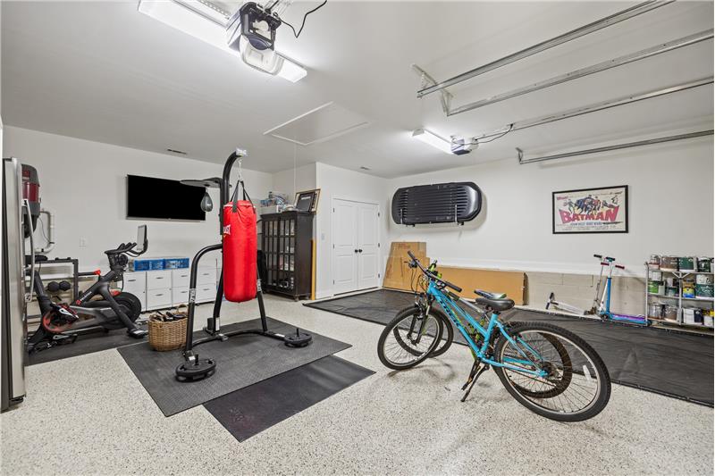 Spacious garage is heated and cooled. Features epoxy flooring, storage, automatic door openers.