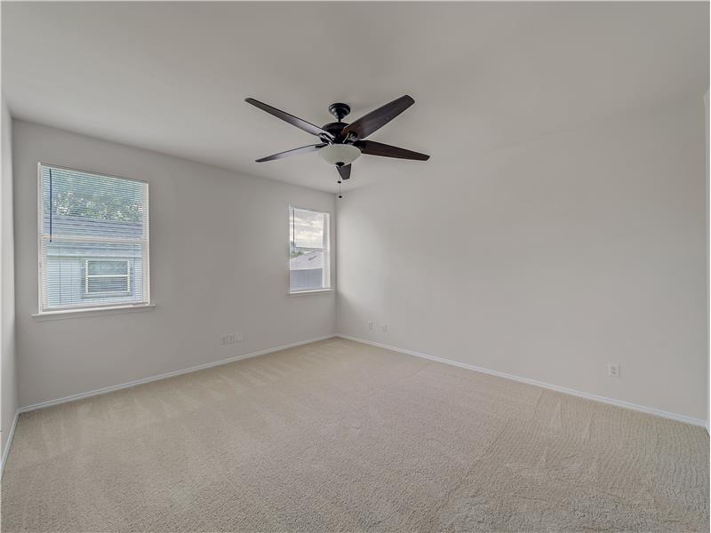 Spacious primary bedroom with new carpet
