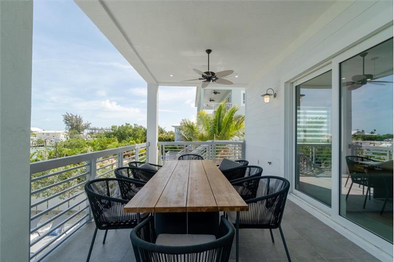 Outdoor dining balcony overlooking the pool and open waters.