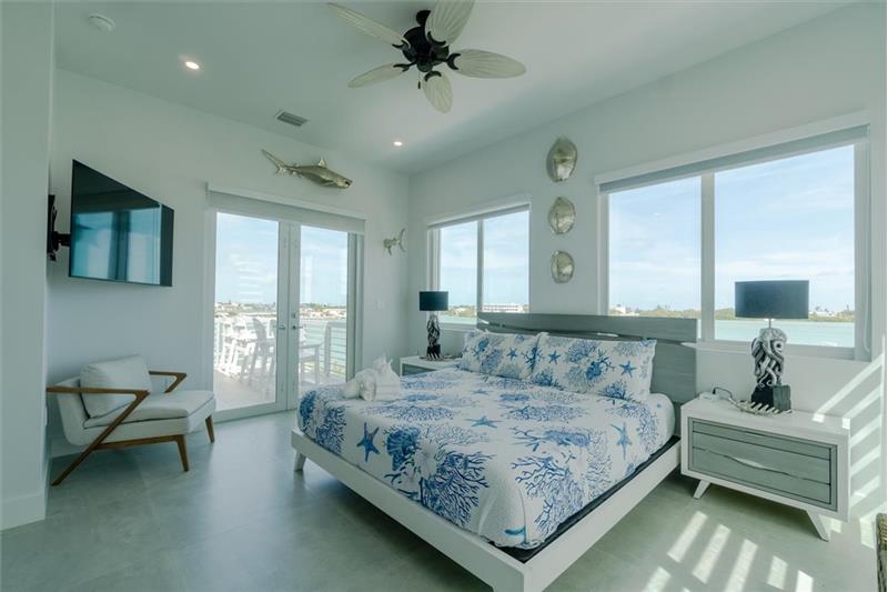 King bedroom master suite with shared balcony overlooking the pool and open water.