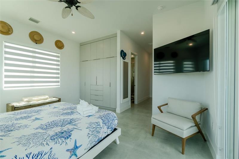 King bedroom master suite with shared balcony overlooking the pool and open water.