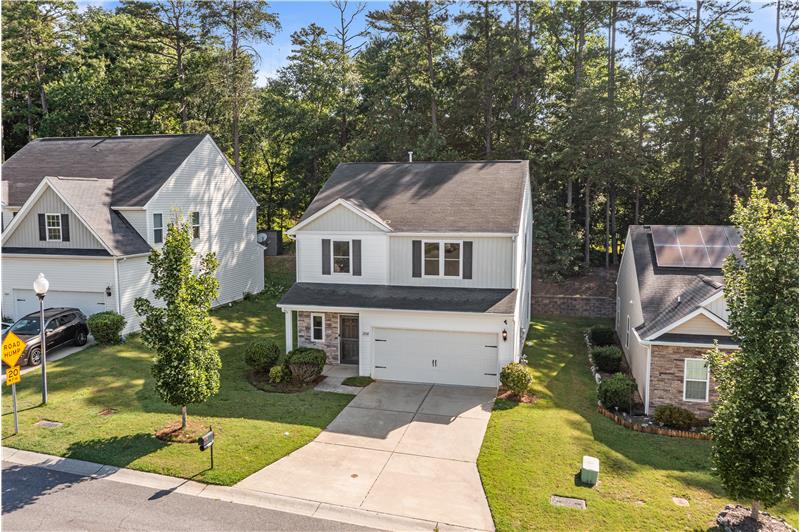 Beautiful curb appeal with backdrop of towering trees