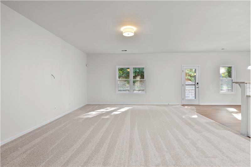 Large great room with open sight lines to dining area and kitchen