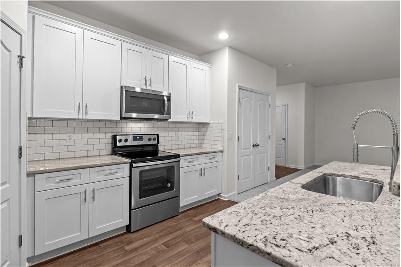 Kitchen has open sight lines to great room and dining area