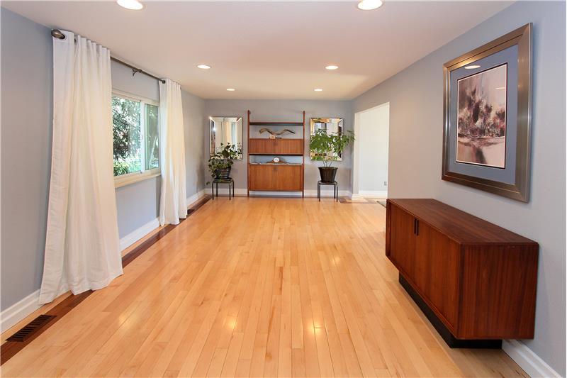 Large living room with maple hardwood flooring and walnut trim