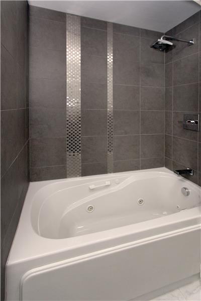Upper level bath with beautiful tile work and jetted tub