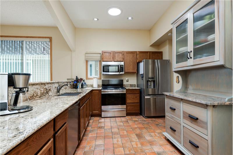 Kitchen has slab granite countertops and stainless steel appliances (all included). Notice the Solatube in ceiling.