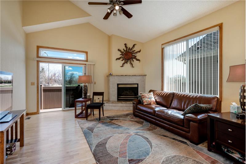 Living room has gas fireplace and sliding gas door to deck with view of open space.