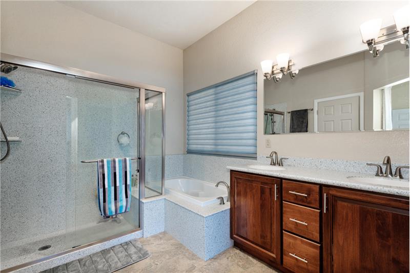 The 5-piece master bathroom has tile floor and Corian countertop for double vanity.